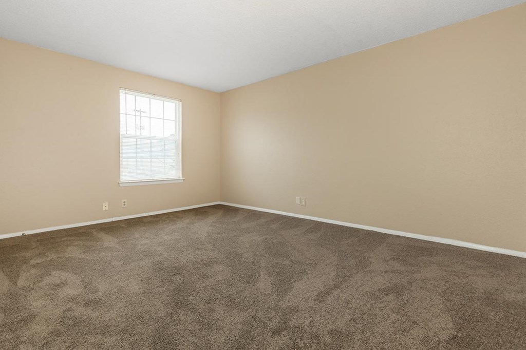 an empty room with carpet and a window