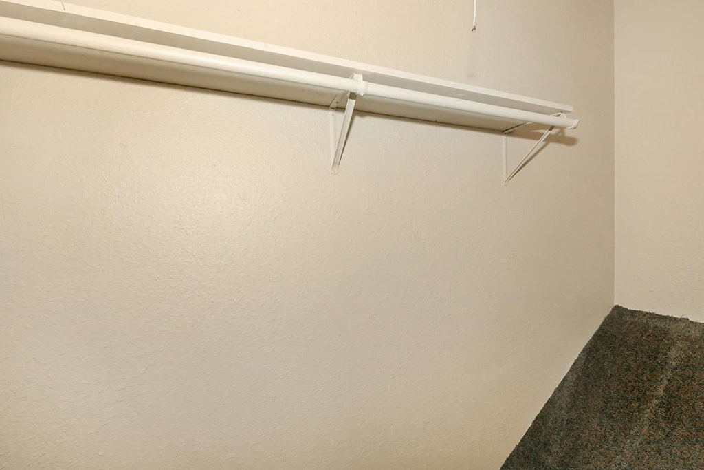 an empty closet in an empty room with a white wall