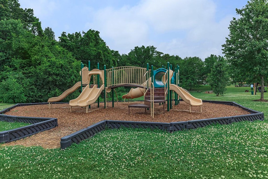a playground with slides and chairs in a park