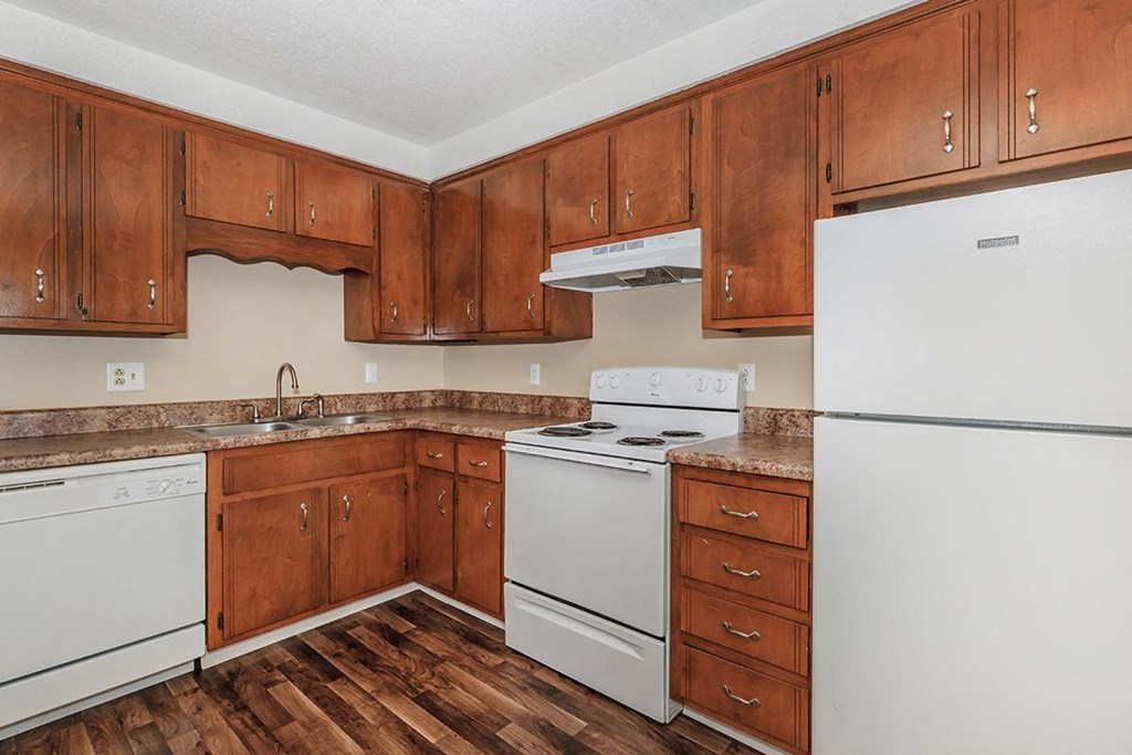 a kitchen with white appliances and wooden cabinets