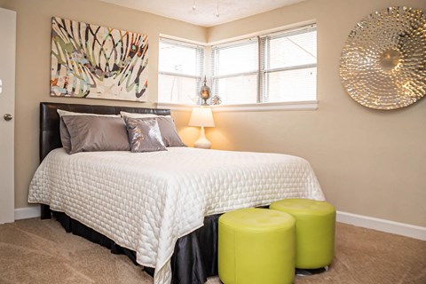 A bedroom with a large bed and a large drum on the wall.