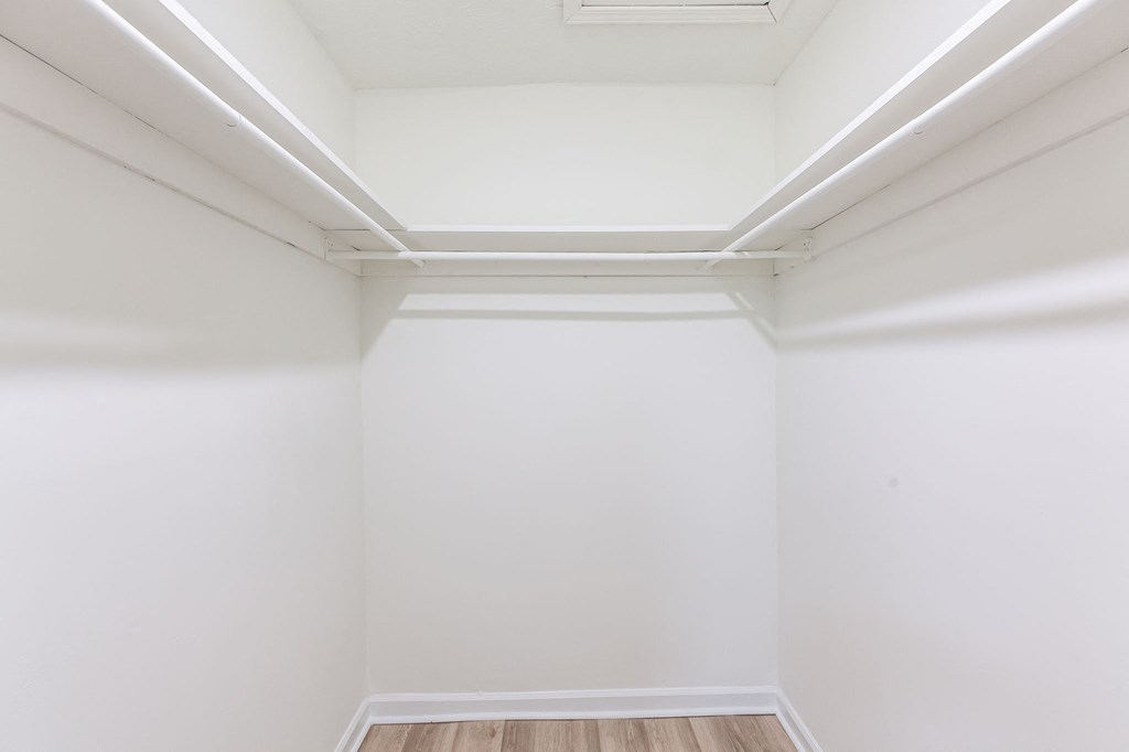 A white room with wooden flooring and white walls.