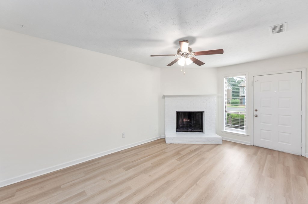 A room with a fireplace and a ceiling fan.