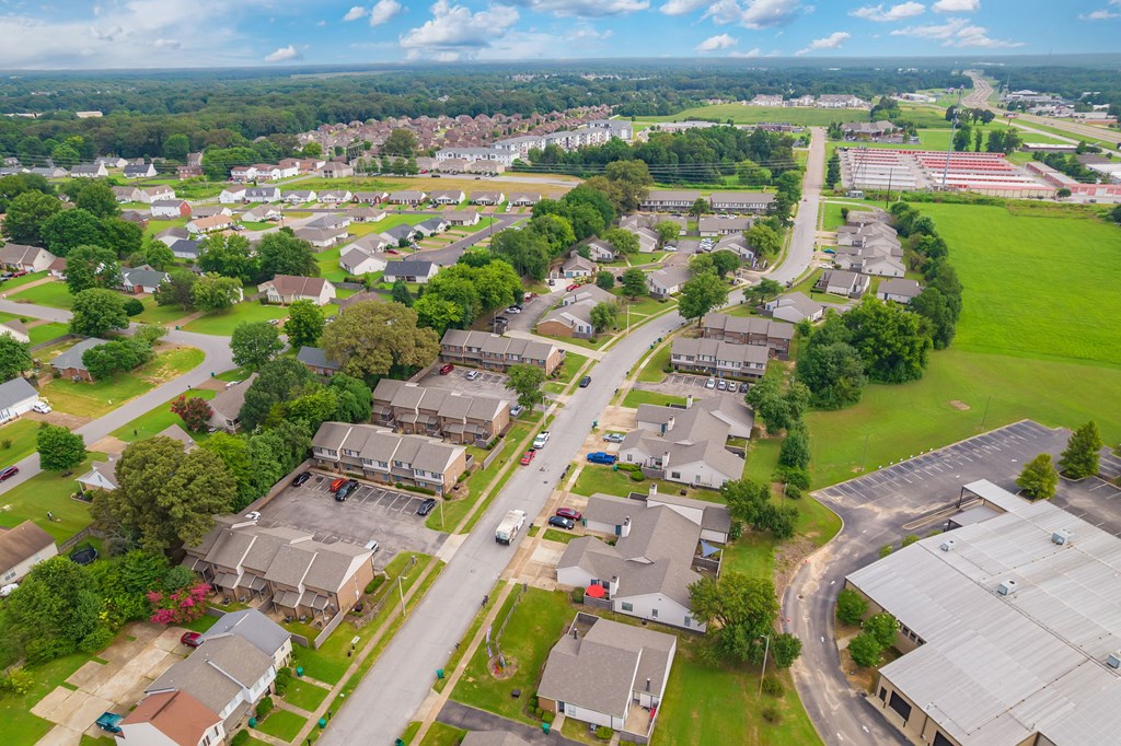 A bird's eye view of a residential area with houses, roads, and greenery.