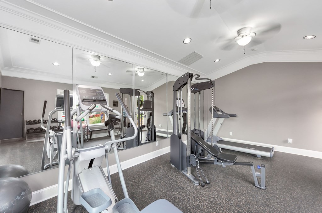 A spacious gym with a variety of equipment including treadmills, weight machines, and free weights.