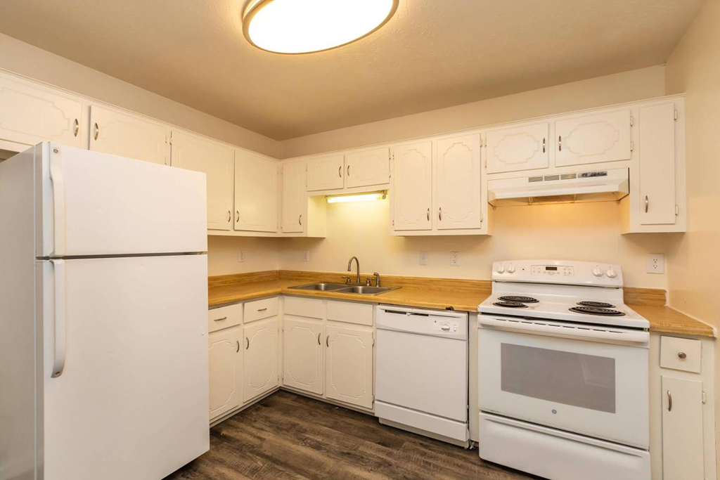 a kitchen with white appliances and white cabinets