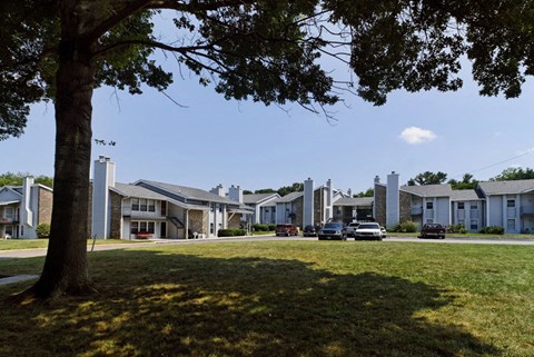 a row of houses with cars parked in the grass