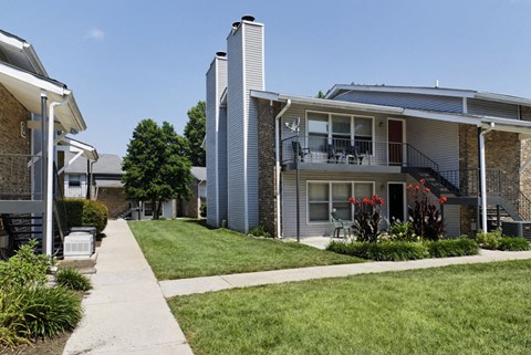 an exterior view of a house with a lawn and a sidewalk