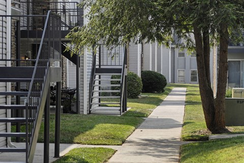 a sidewalk in front of a building with stairs