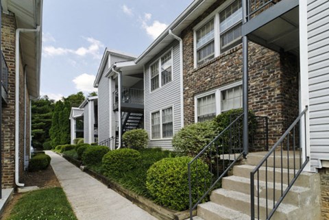 a sidewalk in front of a building with stairs
