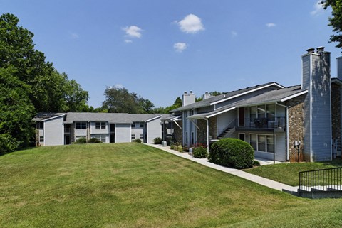 a view of the exterior of a home with a grassy yard and a roof