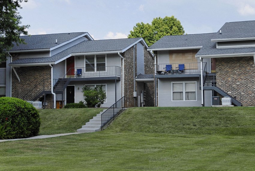a row of houses on a hill with grass