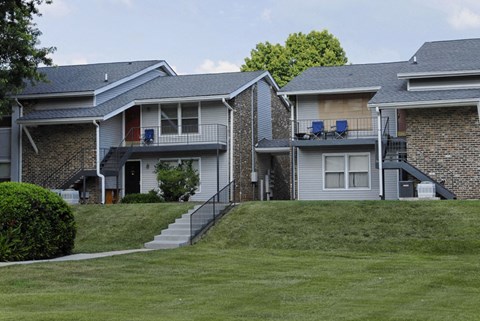 a row of houses on a hill with grass