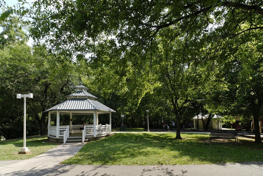 a gazebo in the middle of a park with trees