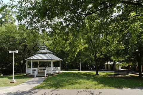 a gazebo in the middle of a park with trees