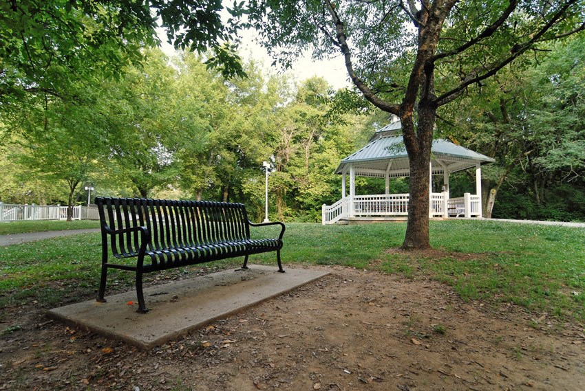 a park bench sitting in front of a gazebo