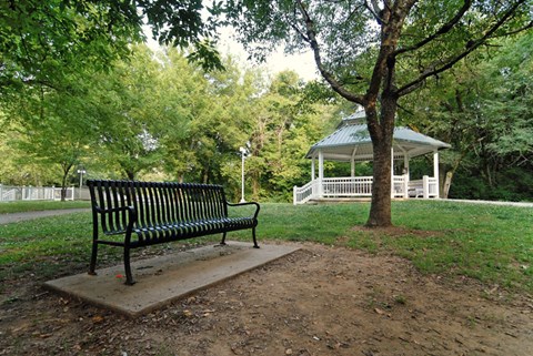 a park bench sitting in front of a gazebo