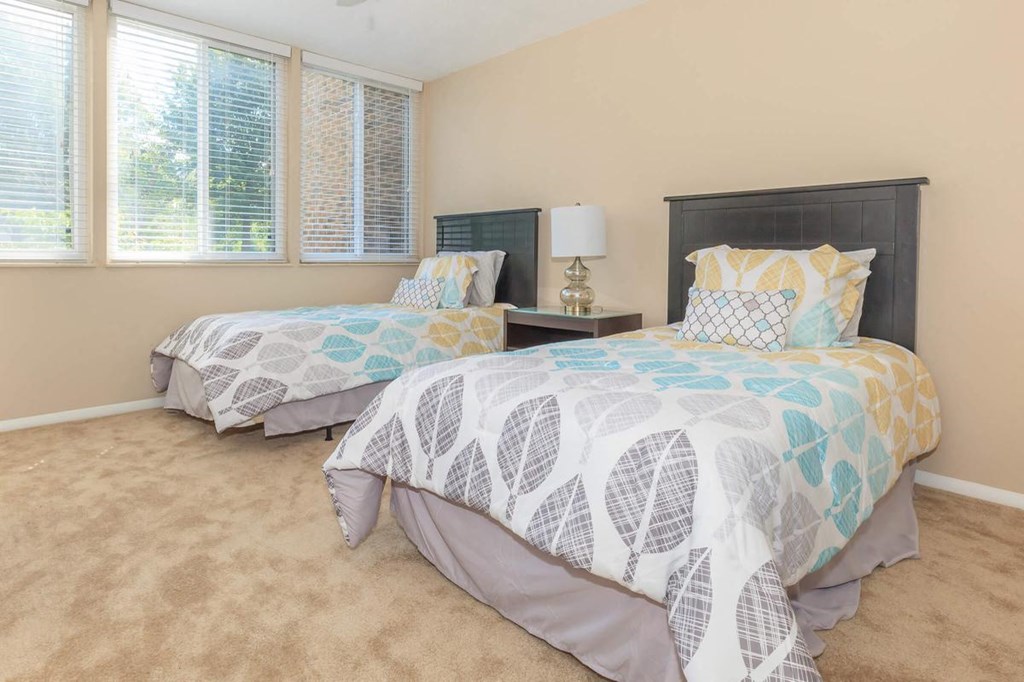 a bedroom with two beds and two windows