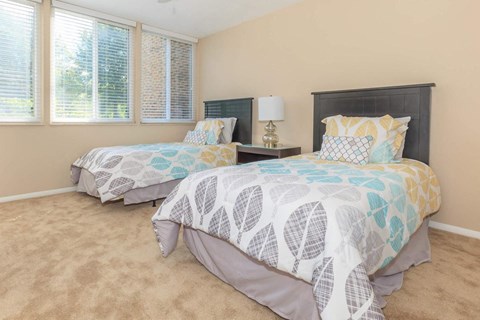 a bedroom with two beds and two windows