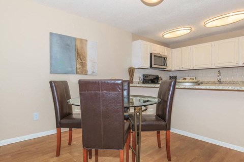 a dining room with a glass table and chairs
