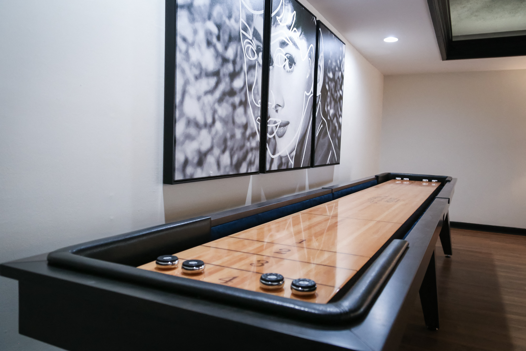 a game room with a ping pong table and a large painting on the wall