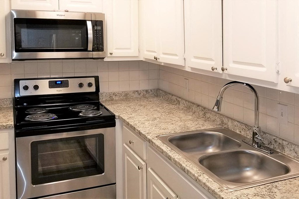 a kitchen with a sink and a stove and a microwave
