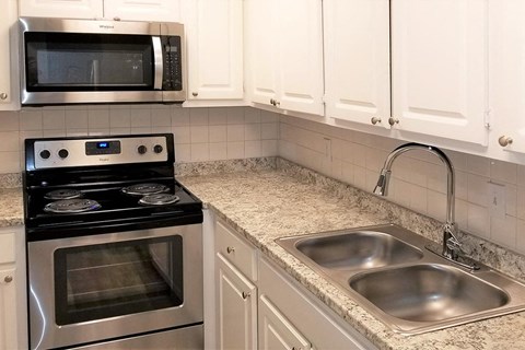 a kitchen with a sink and a stove and a microwave