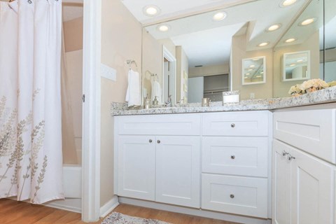 a white bathroom with a large mirror and a counter top