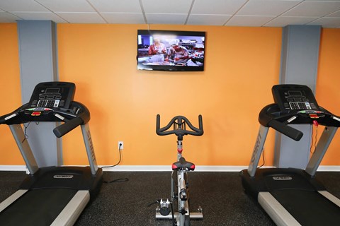a gym with two exercise bikes and a tv on the wall