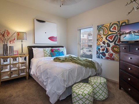 a bedroom with a bed and a dresser and a window
