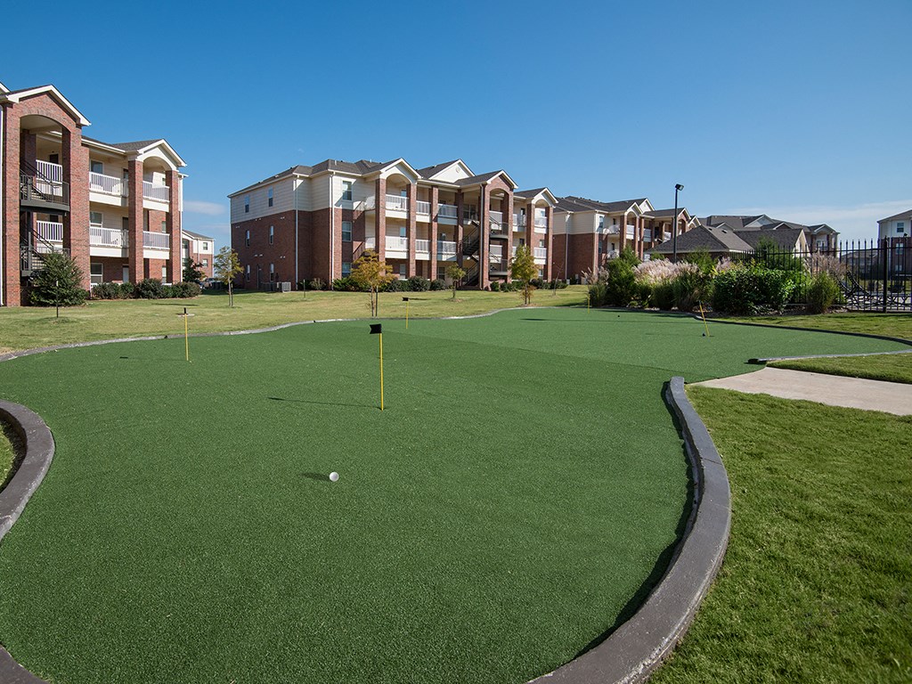 an image of a golf course with apartments in the background