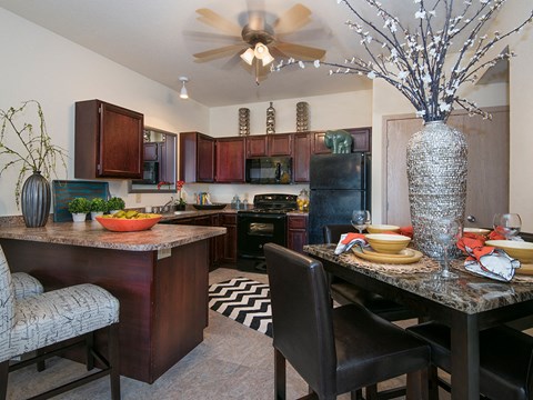 a kitchen and dining area with a table and chairs and a ceiling fan