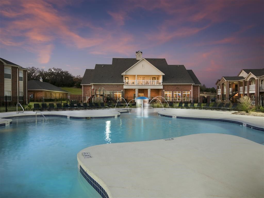 a large swimming pool with a house in the background