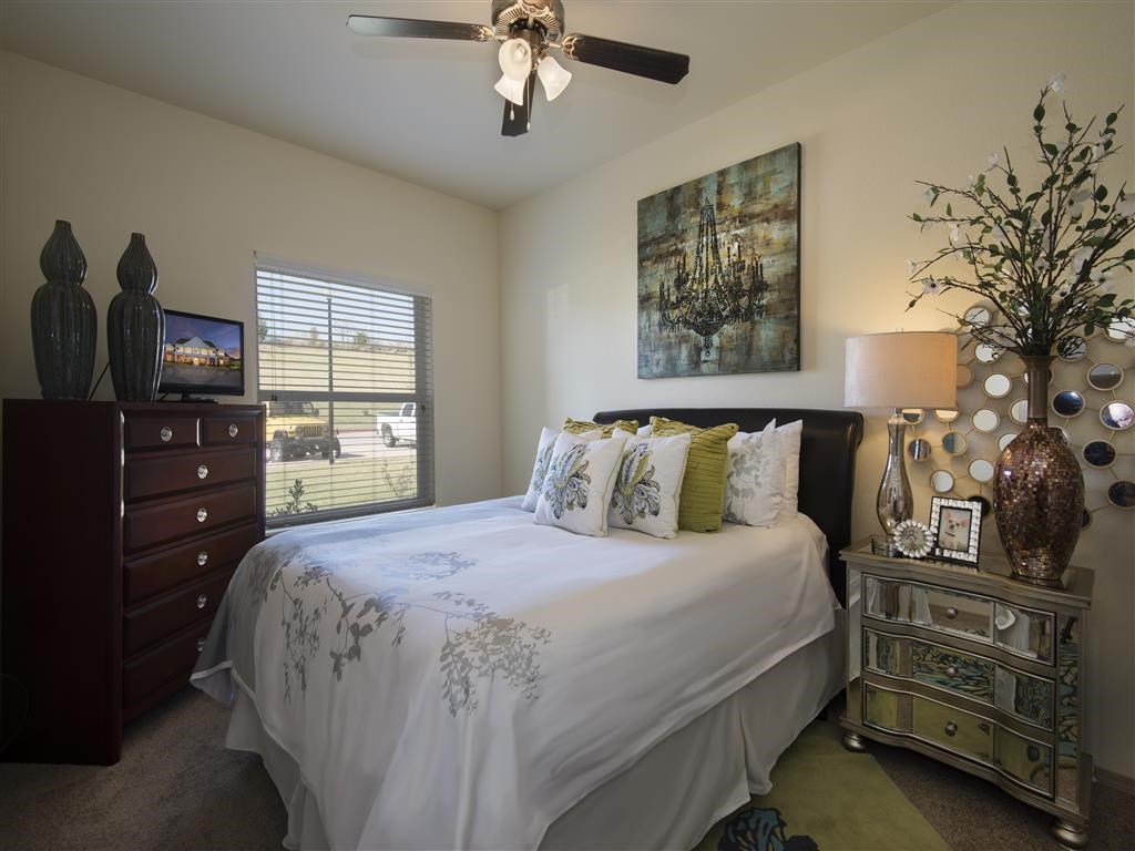 a bedroom with a bed and a ceiling fan