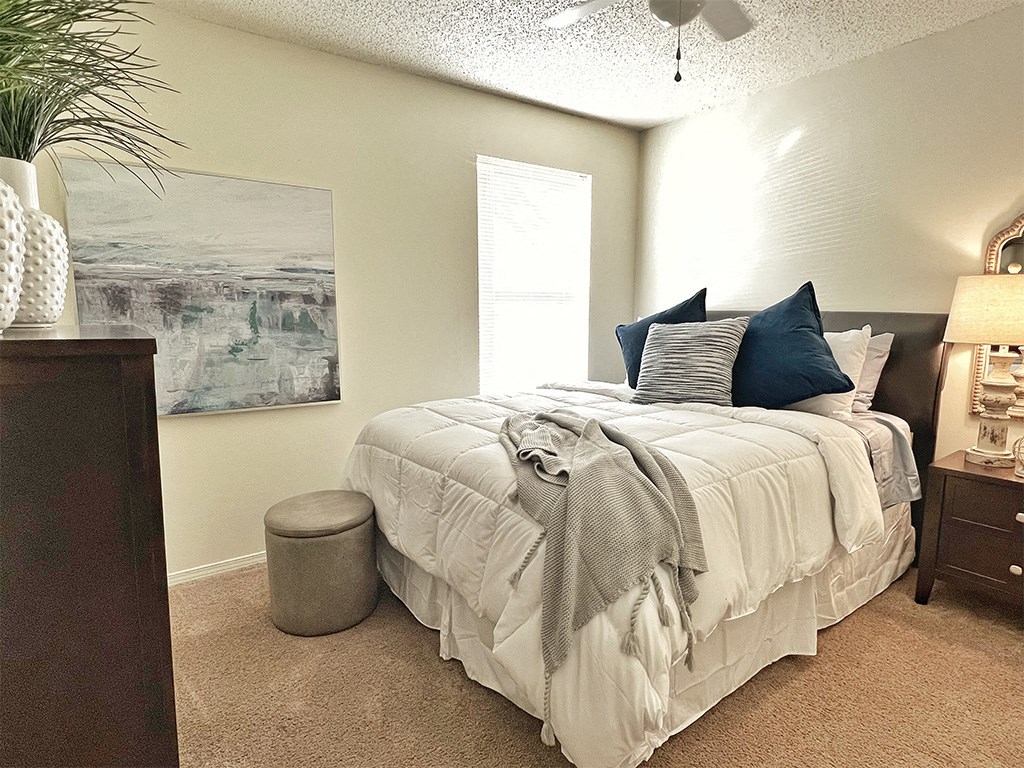 a bedroom with a bed and a dresser and a window