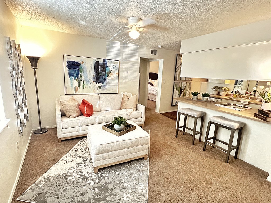 a living room and kitchen with a couch and a table