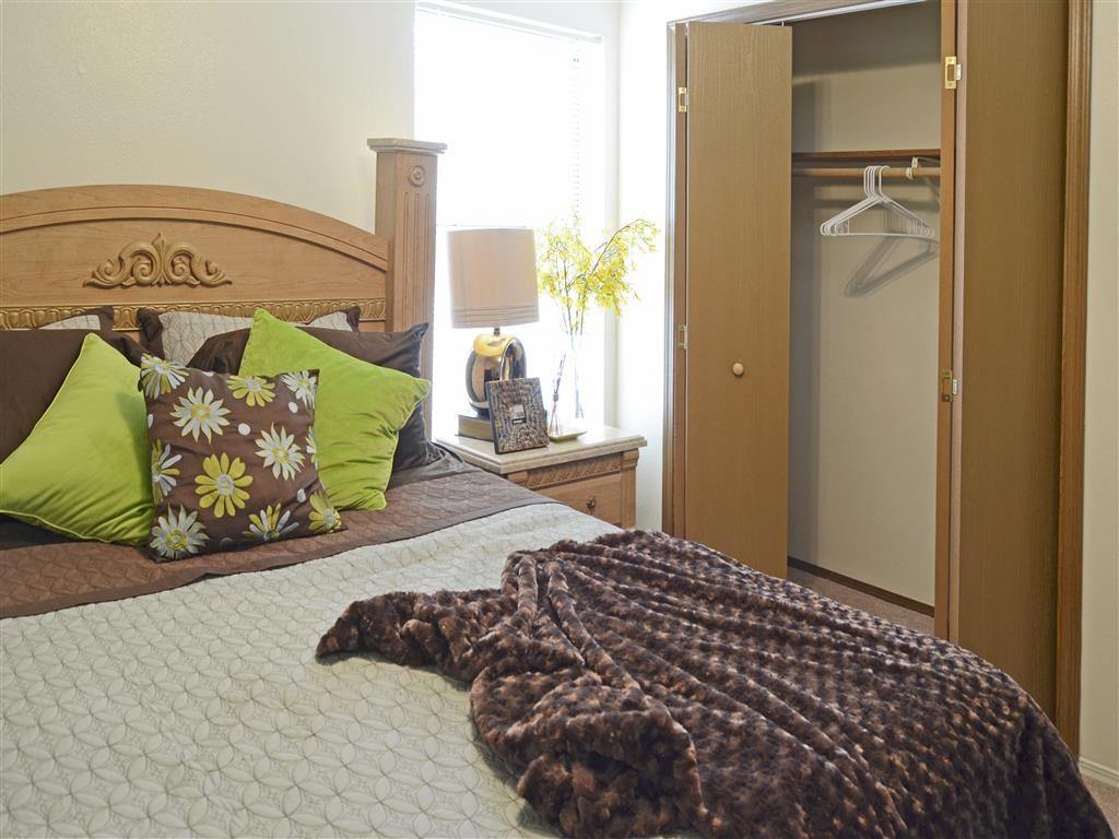 a bedroom with a bed with pillows and a closet