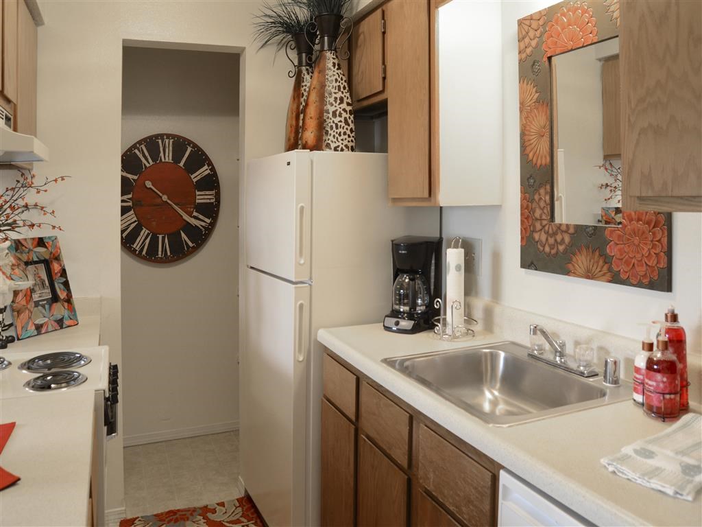 a kitchen with a clock on the wall and a sink