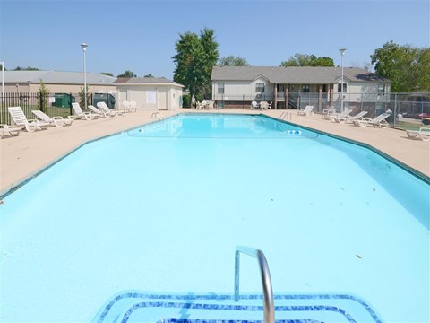 a large swimming pool with chaise lounge chairs around it