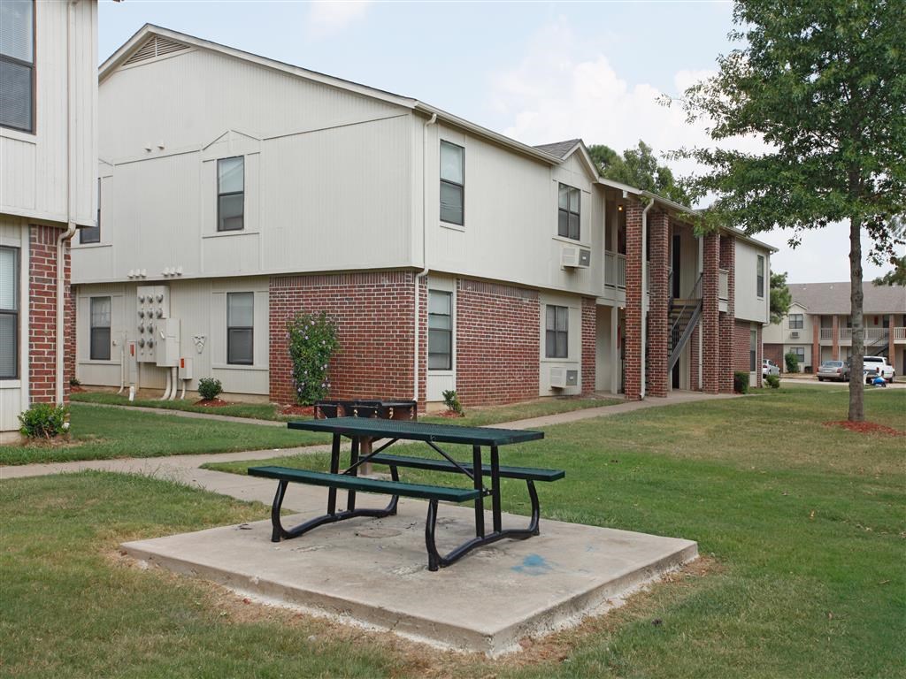 a picnic table sitting in front of an apartment building