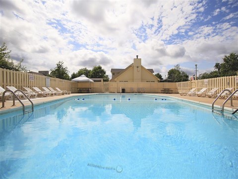 a large pool with chairs and a fence around it