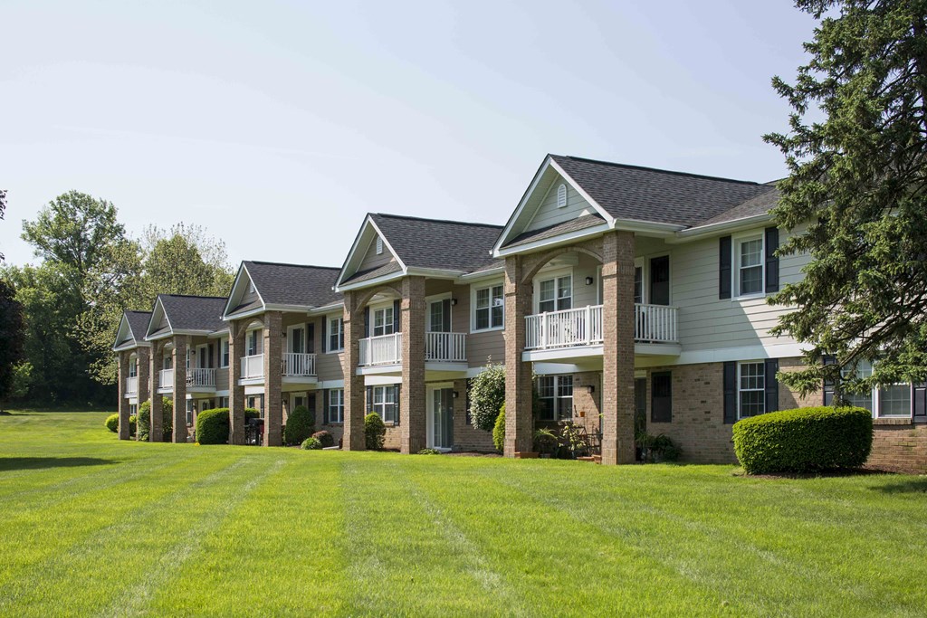 a row of houses with a large yard in front of them