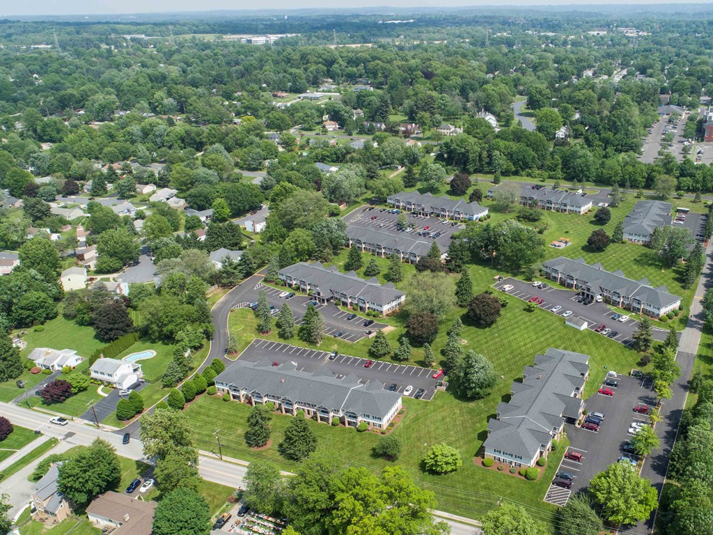an aerial view of a parking lot and rooftops of houses in a suburban neighbourhood
