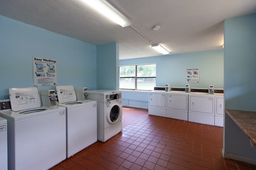 A laundromat with a sign that says "Easy Washing" on the wall.