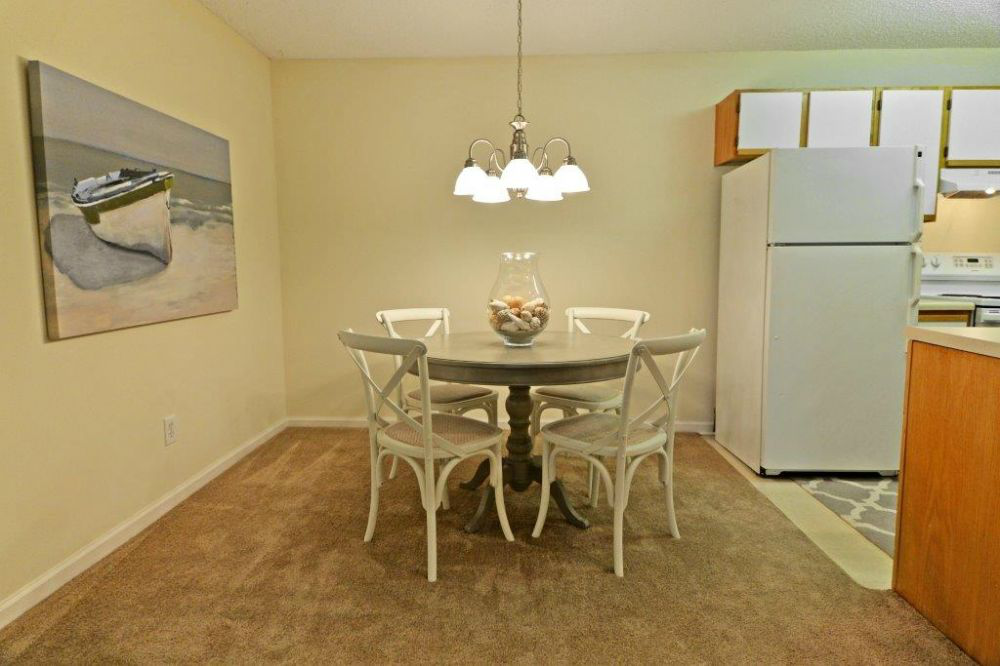 a dining room with a table and chairs and a refrigerator