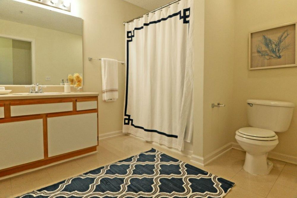a bathroom with a white toilet and a shower curtain