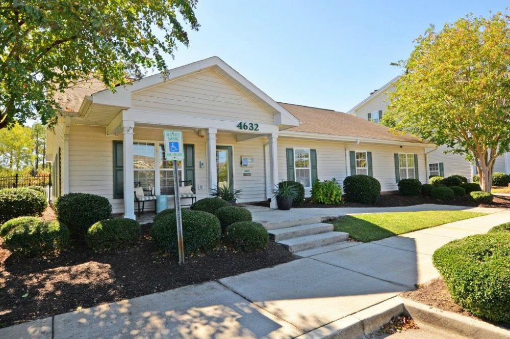 a white house with a sidewalk in front of it