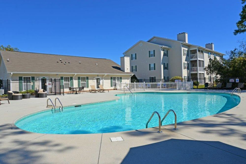 a swimming pool with an apartment building in the background