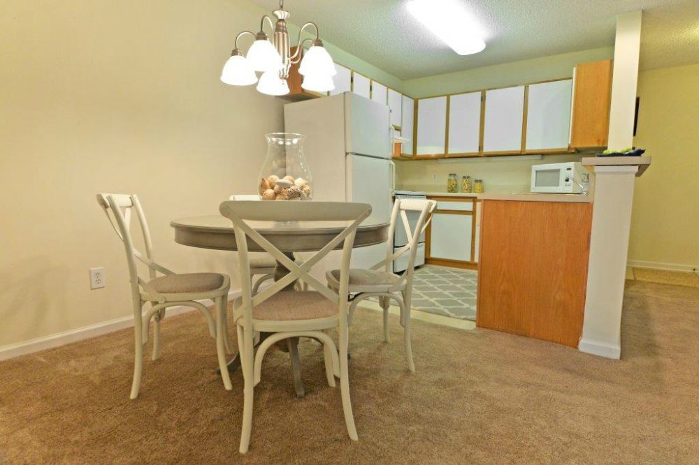 a kitchen with a table and chairs and a refrigerator