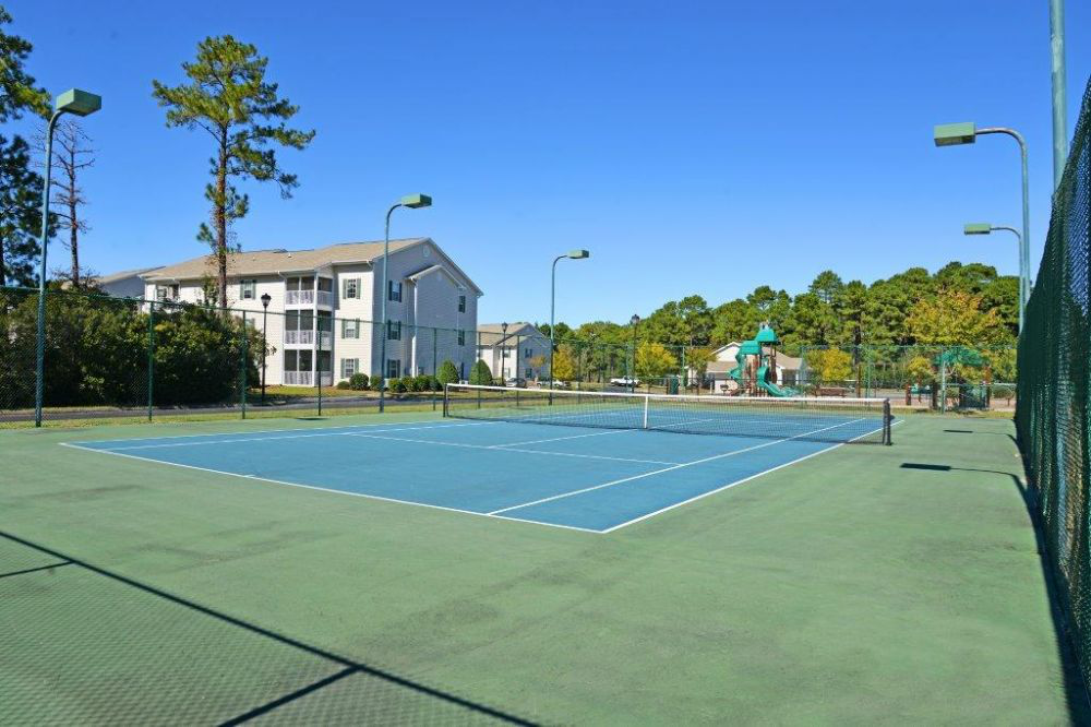 a tennis court with a building in the background